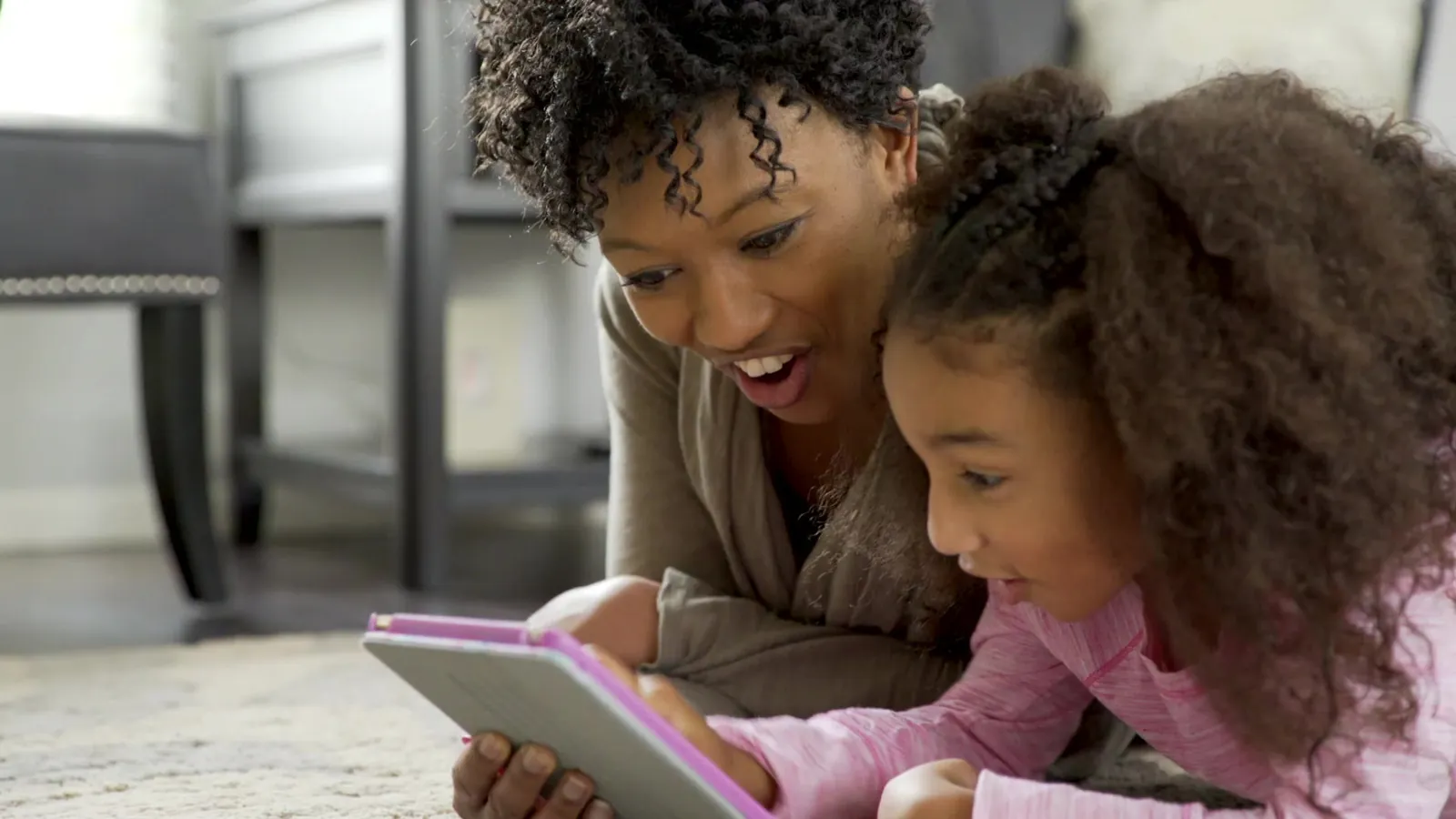 A parent and child looking at a tablet together