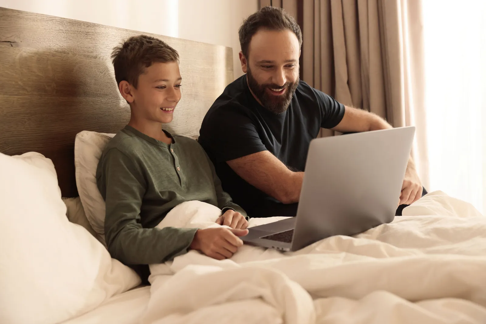 A father and son looking at a laptop together