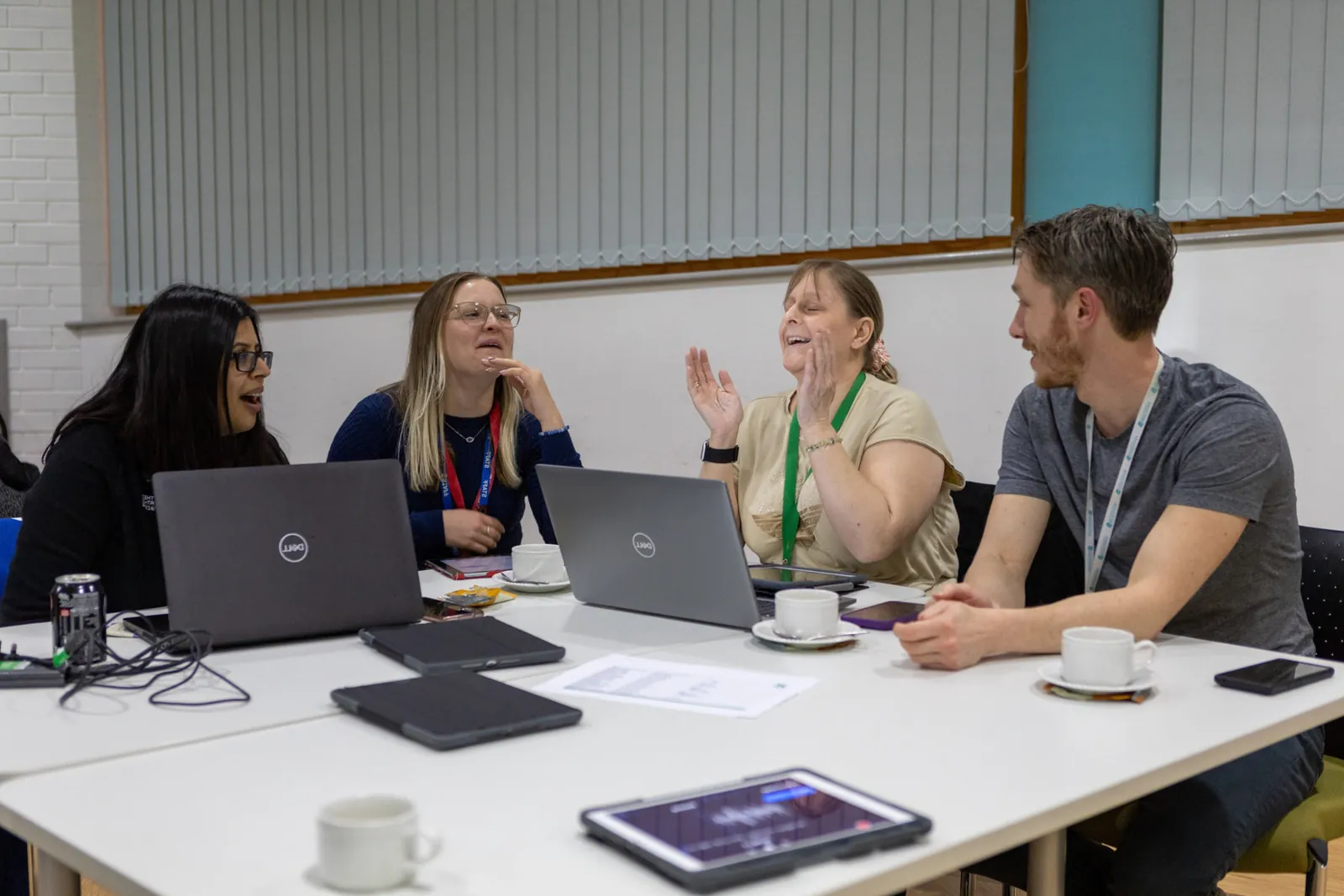 Teachers working together with laptops at a training session
